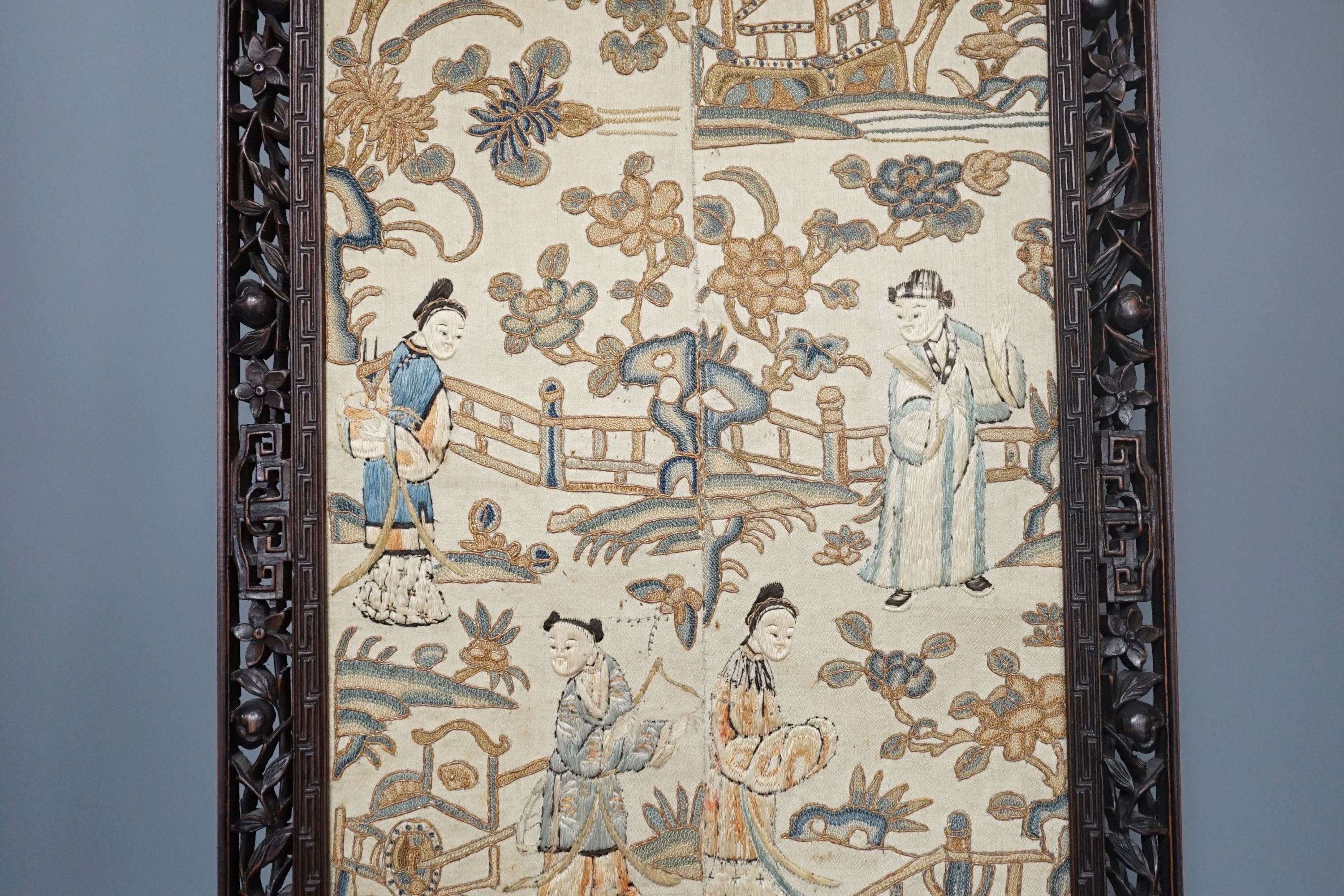 A pair of Chinese silk Beijing knot embroidered sleeve bands in a carved rosewood frame, 22 cms wide x 58.5 cms high, including frame.
